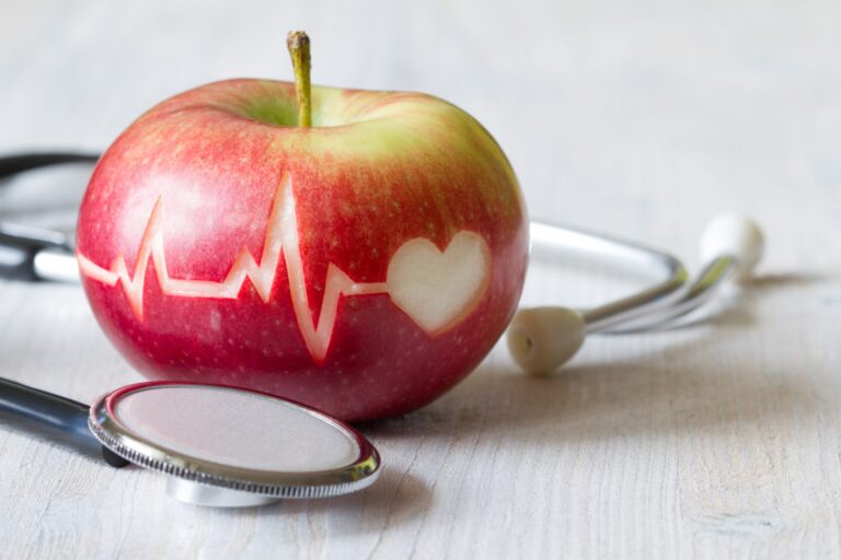 Roter Apfel mit EKG-Linie und Stethoskop