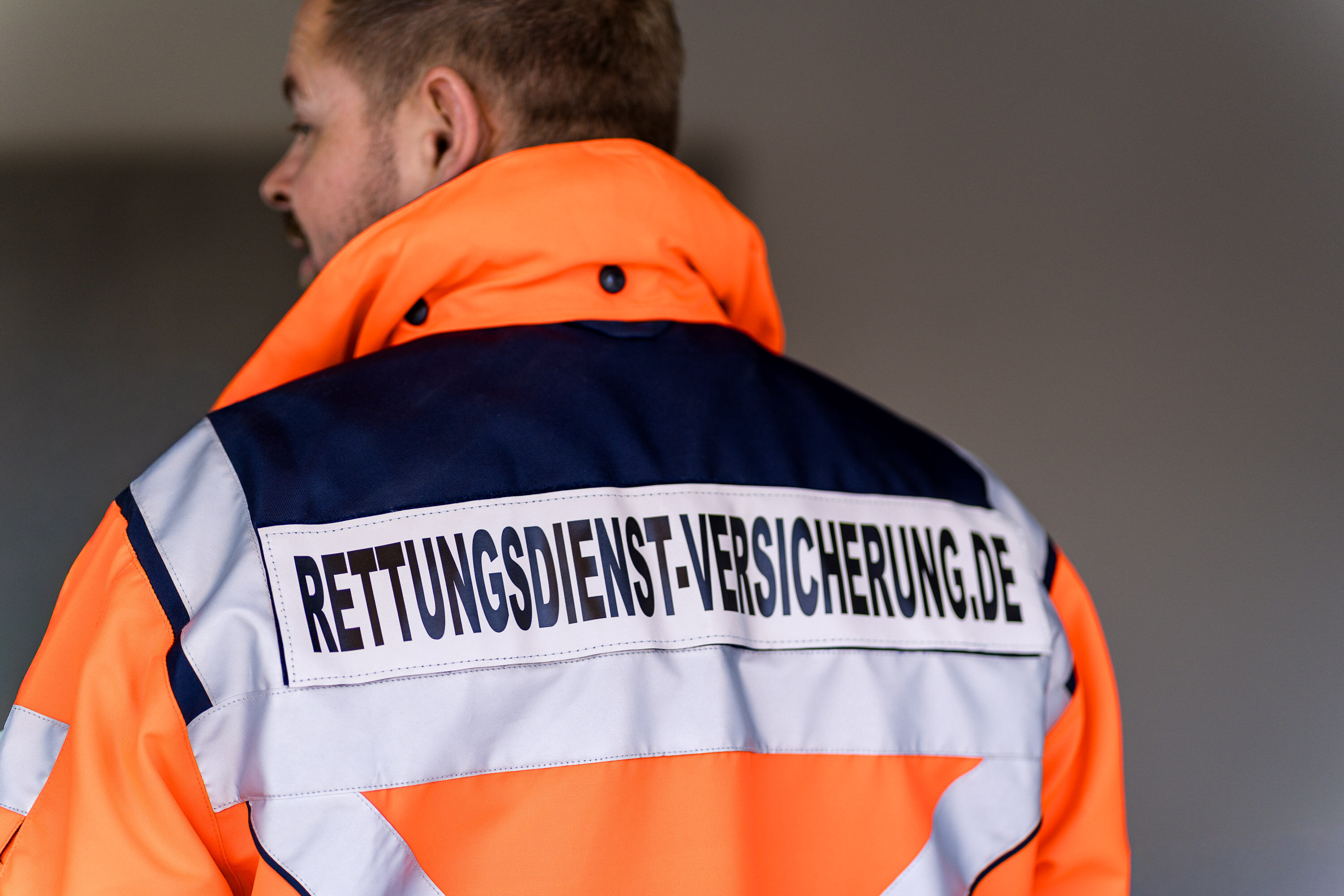 Nikki Pahl von hinten in der Einsatzjacke mit Rückenaufdruck Rettungsdienst-Versicherung.de